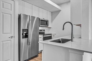A kitchen with a sink and a refrigerator